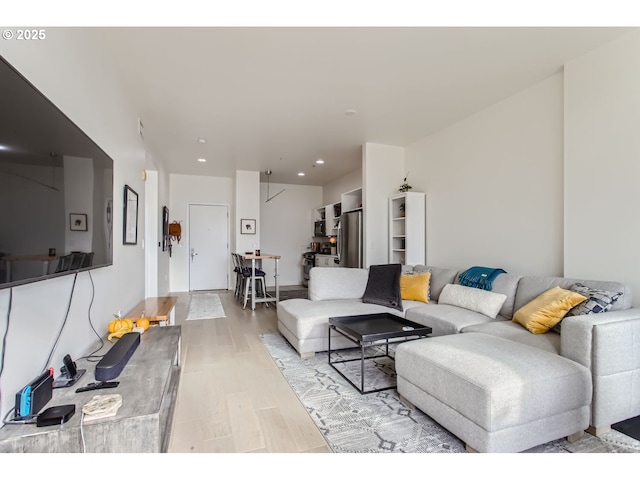 living room with recessed lighting and light wood-style flooring