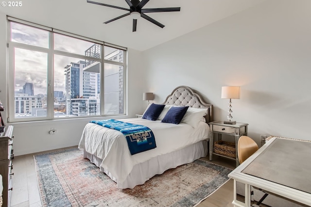 1255 NW 9th Ave Unit 806, Portland, OR 97209 - bedroom with a view of city, ceiling fan, and wood finished floors