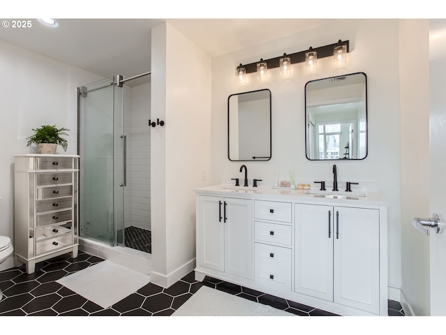 bathroom with a sink, a stall shower, and double vanity