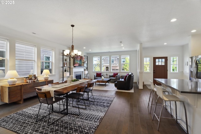 14878 NW Olive St, Portland, OR 97229 - dining area featuring recessed lighting, a notable chandelier, dark wood-style floors, and a fireplace