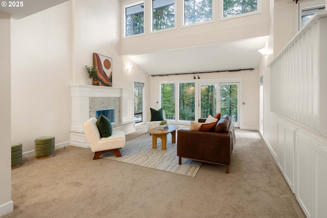 living room featuring a high ceiling, light carpet, and a fireplace