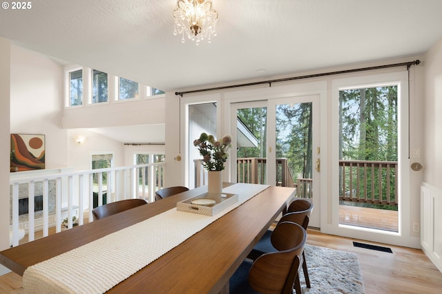 dining room with plenty of natural light, a notable chandelier, and light hardwood / wood-style floors