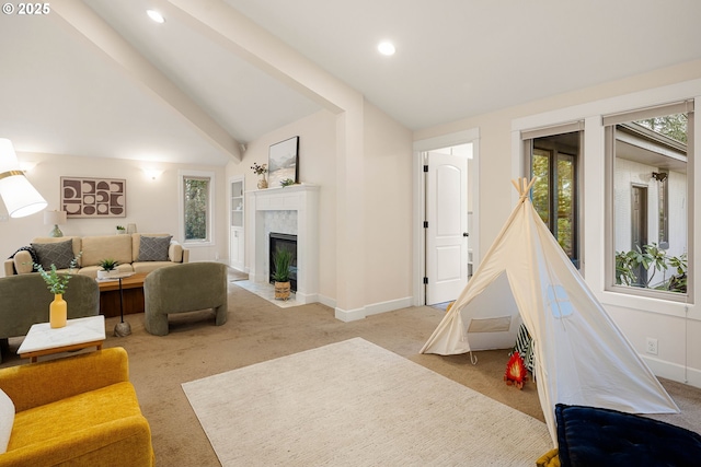 recreation room featuring lofted ceiling with beams, a premium fireplace, and light carpet