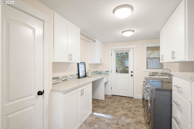 kitchen featuring washer and dryer and white cabinets