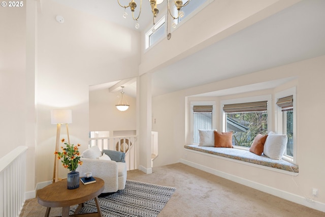 living area with a high ceiling, carpet flooring, and a chandelier