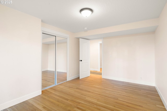 unfurnished bedroom with light hardwood / wood-style floors and a closet