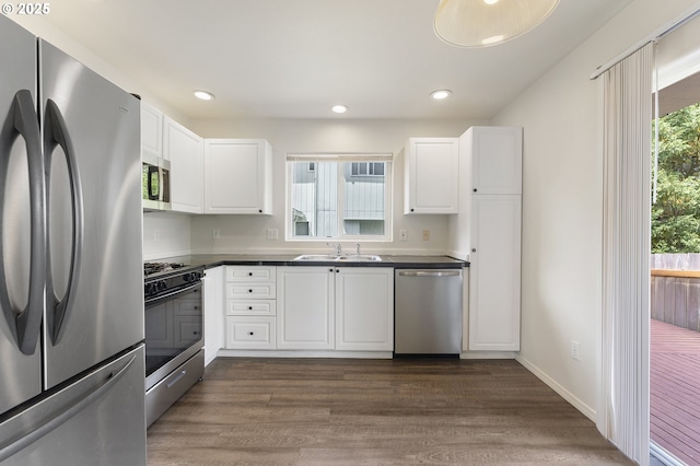 15629 NW Energia St, Portland, OR 97229 - kitchen with appliances with stainless steel finishes, dark countertops, white cabinets, dark wood-style flooring, and recessed lighting