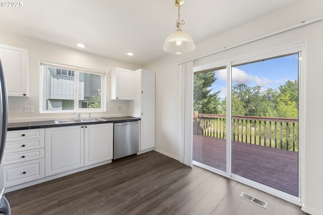 15629 NW Energia St, Portland, OR 97229 - kitchen featuring stainless steel dishwasher, dark countertops, dark wood-type flooring, white cabinets, and recessed lighting