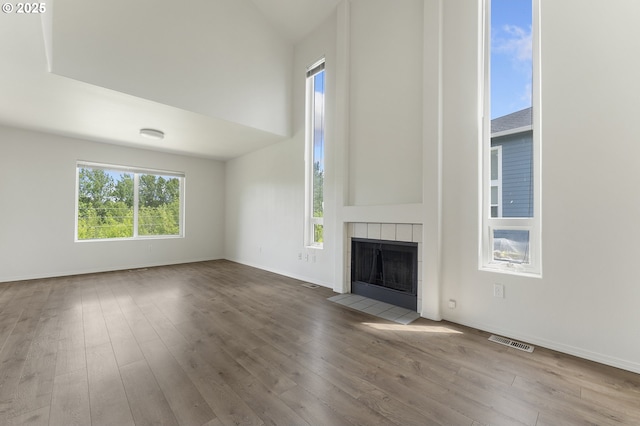 15629 NW Energia St, Portland, OR 97229 - unfurnished living room with a tiled fireplace, wood finished floors, and high vaulted ceiling