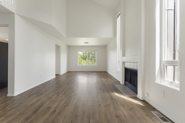 15629 NW Energia St, Portland, OR 97229 - unfurnished living room with high vaulted ceiling, a fireplace, and dark wood-style floors