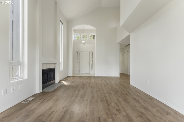 15629 NW Energia St, Portland, OR 97229 - unfurnished living room featuring high vaulted ceiling, wood finished floors, a fireplace, and arched walkways