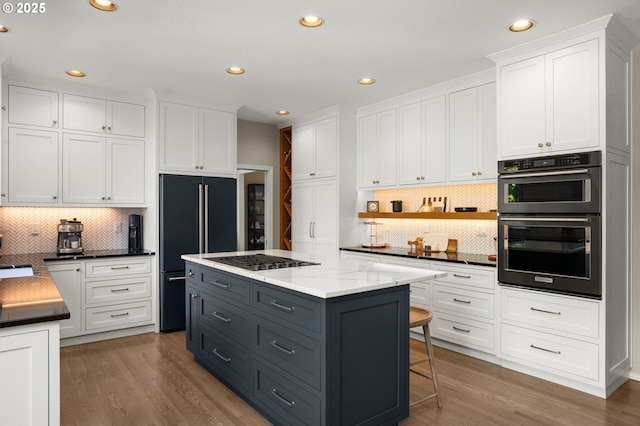 1648 NW 127th Ter, Portland, OR 97229 - kitchen with high quality fridge, stainless steel gas cooktop, white cabinets, tasteful backsplash, and recessed lighting
