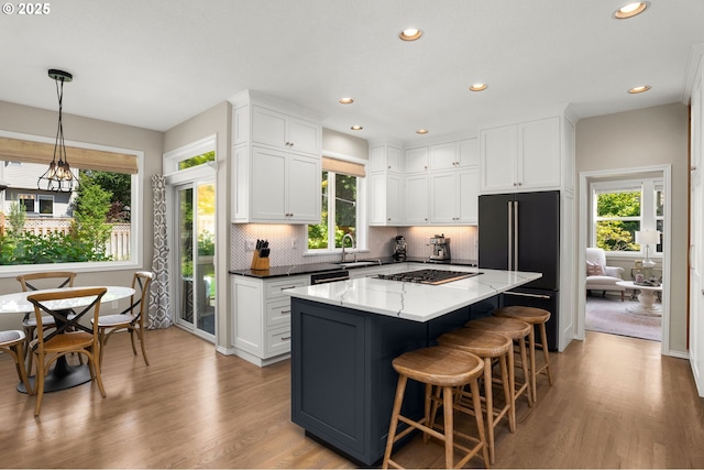1648 NW 127th Ter, Portland, OR 97229 - kitchen featuring high quality fridge, white cabinetry, light wood-style flooring, a center island, and recessed lighting