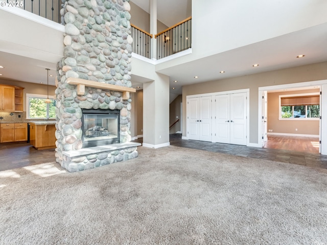10193 SE Crescent Ridge Loop, Happy Valley, OR 97086 - unfurnished living room featuring carpet flooring, a stone fireplace, a high ceiling, recessed lighting, and stairs