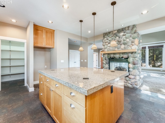 10193 SE Crescent Ridge Loop, Happy Valley, OR 97086 - kitchen featuring dark stone finish floors, a stone fireplace, a center island, light countertops, and recessed lighting