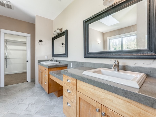 10193 SE Crescent Ridge Loop, Happy Valley, OR 97086 - bathroom featuring two vanities, a skylight, and a spacious closet
