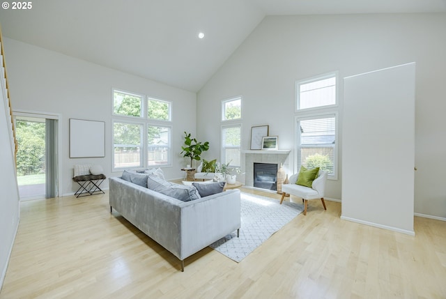 3618 Sterling Woods Dr, Eugene, OR 97408 - living room with high vaulted ceiling, a tiled fireplace, light wood-style floors, and baseboards