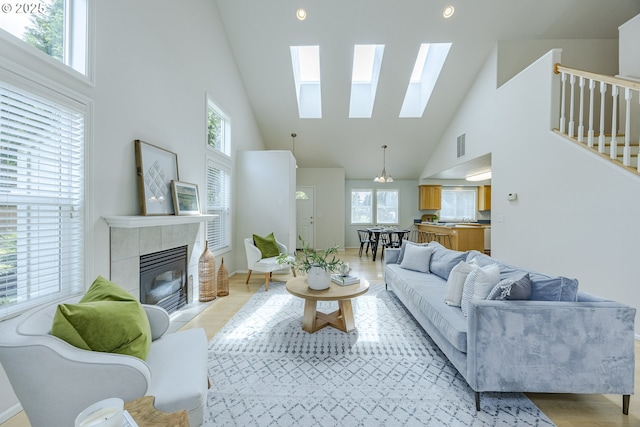 3618 Sterling Woods Dr, Eugene, OR 97408 - living area featuring high vaulted ceiling, a skylight, a tiled fireplace, and light wood-style floors