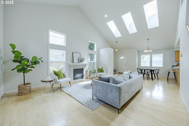3618 Sterling Woods Dr, Eugene, OR 97408 - living room featuring high vaulted ceiling, a skylight, a chandelier, a fireplace, and light wood finished floors