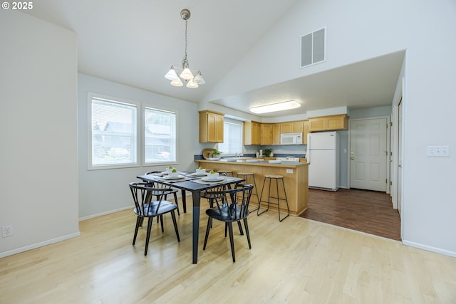 3618 Sterling Woods Dr, Eugene, OR 97408 - dining space with light wood-style flooring, a chandelier, baseboards, and high vaulted ceiling