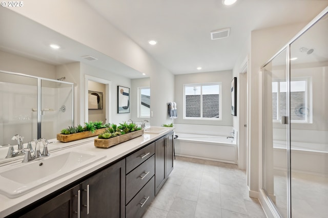 bathroom with a shower stall, a garden tub, double vanity, and a sink
