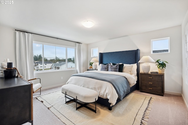 bedroom featuring baseboards, multiple windows, and light carpet