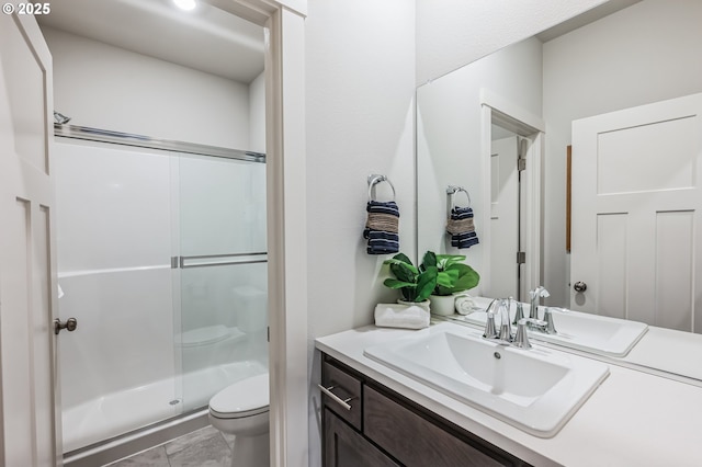 full bathroom with a stall shower, vanity, toilet, and marble finish floor