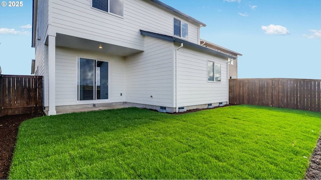 back of house featuring a yard and a fenced backyard