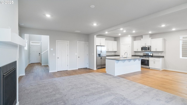 kitchen with light wood finished floors, recessed lighting, open floor plan, and appliances with stainless steel finishes