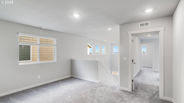 spare room with carpet floors, baseboards, visible vents, and recessed lighting