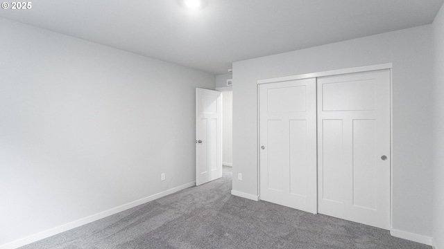 unfurnished bedroom featuring a closet, baseboards, and carpet floors