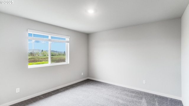 empty room featuring baseboards and carpet floors