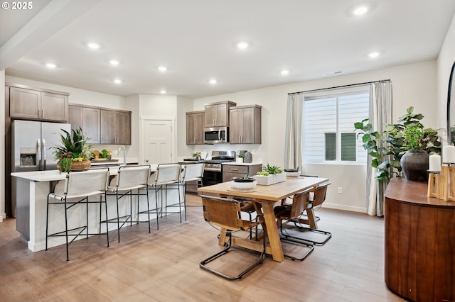 dining room with light wood finished floors, baseboards, and recessed lighting