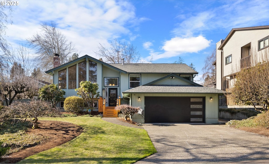 split foyer home with a garage and a front yard