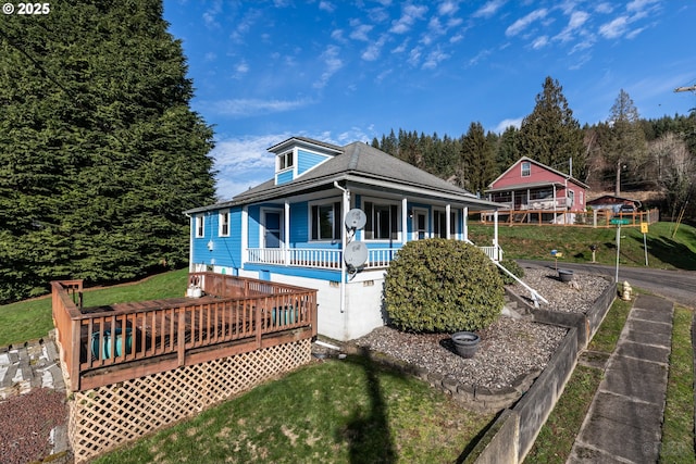 country-style home with a front yard and a deck