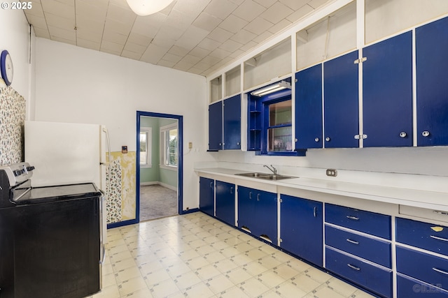 kitchen featuring blue cabinets, sink, white refrigerator, and stainless steel electric range oven