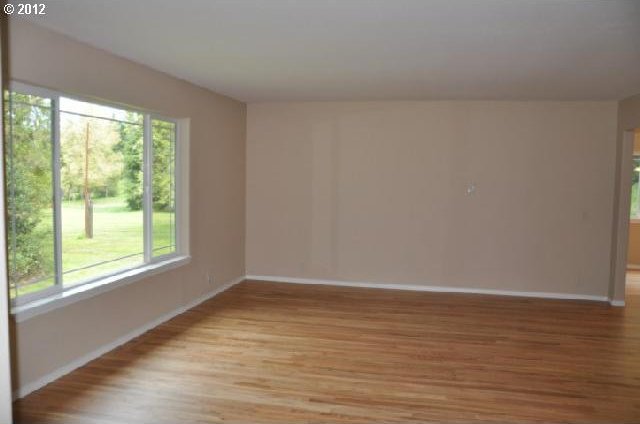 unfurnished room with light wood finished floors and baseboards