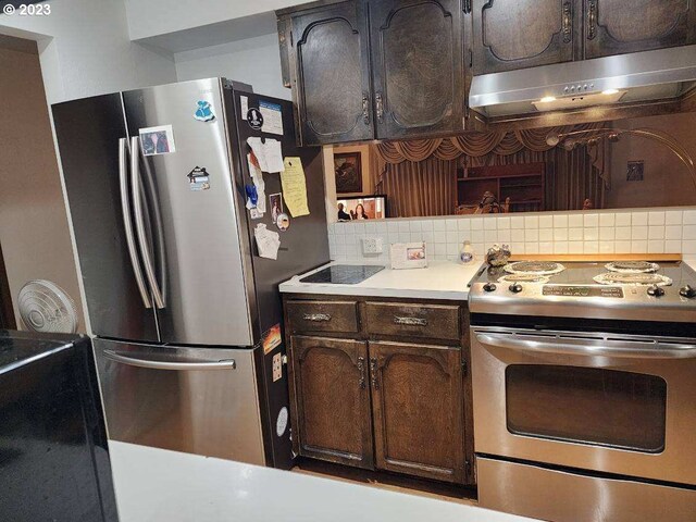 5723 NE Hazel Dell Ave Unit B, Vancouver, WA 98663 - kitchen featuring appliances with stainless steel finishes, under cabinet range hood, backsplash, light countertops, and dark brown cabinets