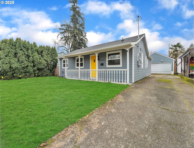 view of front of house featuring an outbuilding, covered porch, a front lawn, and a garage