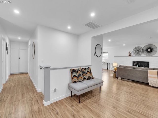 sitting room featuring a fireplace and light wood-type flooring