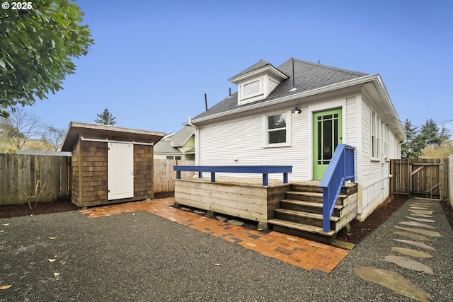 back of house featuring a storage unit and a patio area