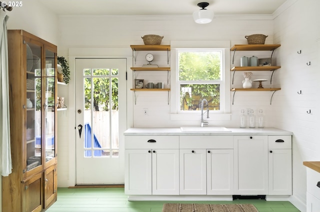 interior space with white cabinetry and sink