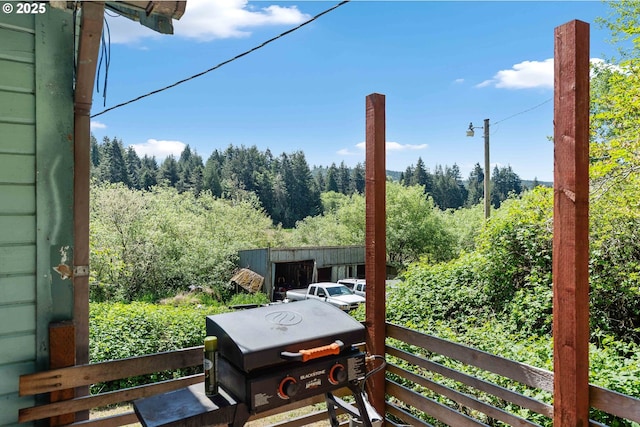 balcony featuring a grill and a view of trees