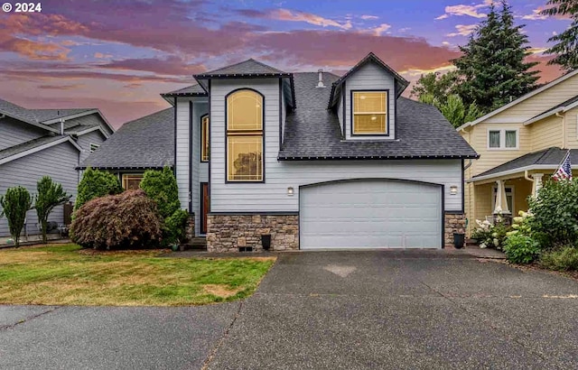 view of front of house featuring a garage and a lawn