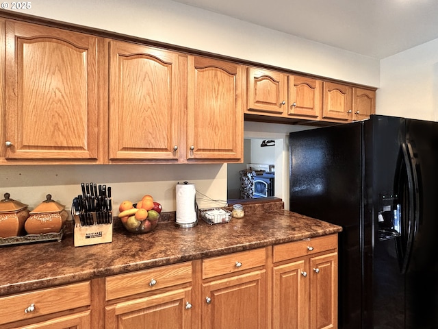 kitchen with brown cabinetry and black fridge with ice dispenser