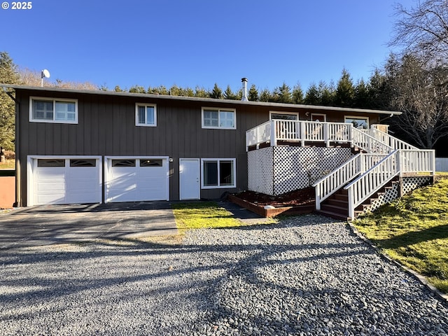 view of front of home with stairs, a garage, and driveway