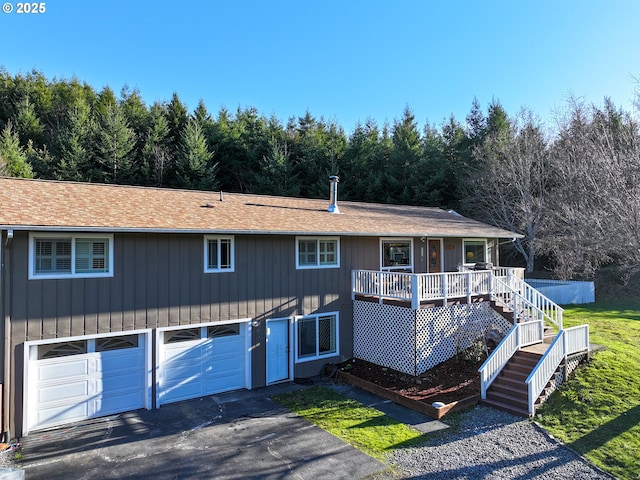 view of front of property with aphalt driveway, an attached garage, and stairs