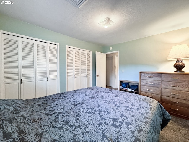 bedroom featuring multiple closets, carpet floors, and a textured ceiling