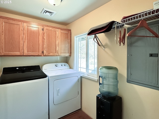 washroom with electric panel, visible vents, cabinet space, and washing machine and clothes dryer