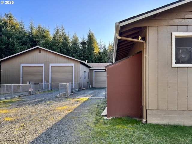 view of side of property featuring an outbuilding, fence, and a garage